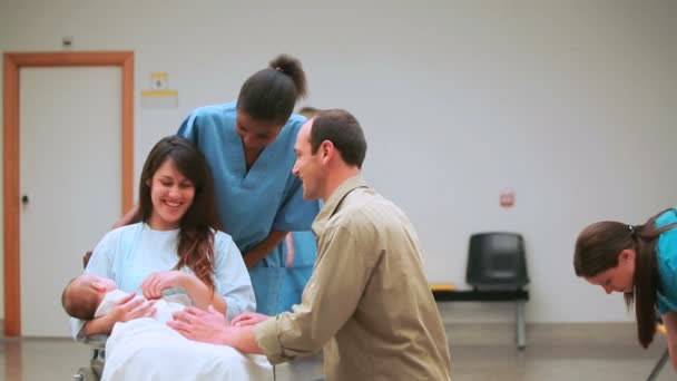 Nurse with a mother and a father with their baby on a wheelchair — Stock Video