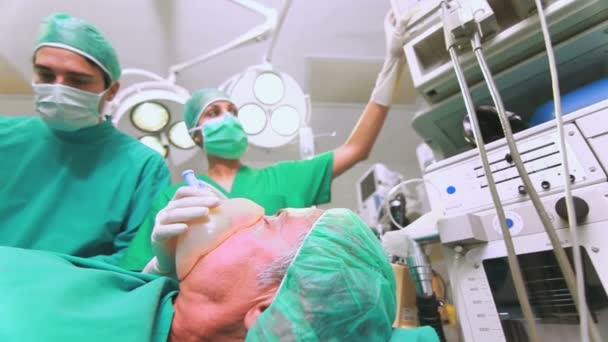 Enfermeira ajustando um monitor ao lado de um paciente — Vídeo de Stock