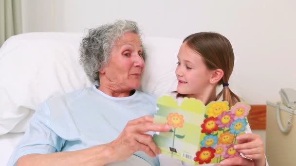 Mãe e menina sorridente sentados na cama de um paciente — Vídeo de Stock