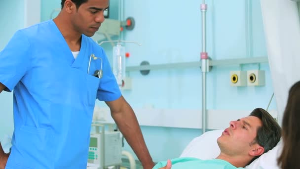 Чоловіча медсестра розмовляє з пацієнтом — стокове відео