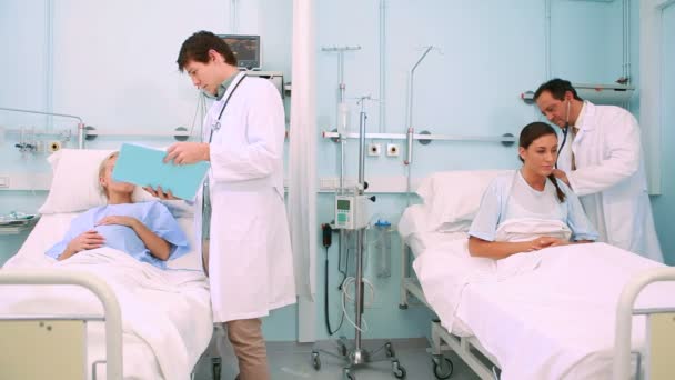 Położnik mówi do pacjenta leżącego w łóżku — Wideo stockowe