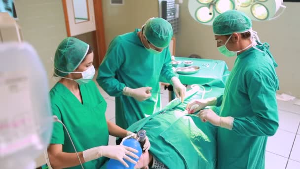 Groep van chirurgen bezig met een vrouwelijke patiënt — Stockvideo