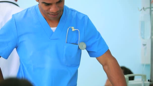 Male nurse talking to a patient with a doctor — Stock Video