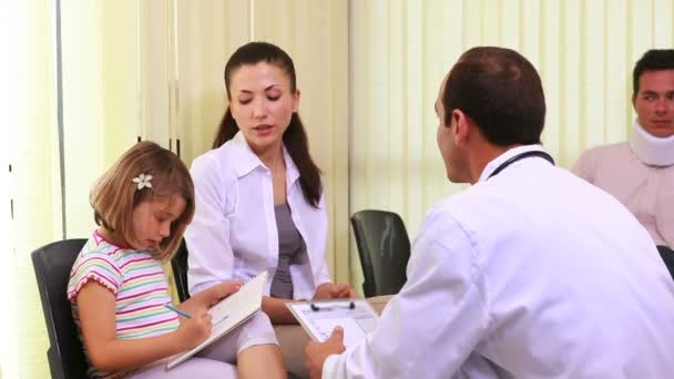 Pacientes conversando com um médico na sala de espera — Vídeo de Stock