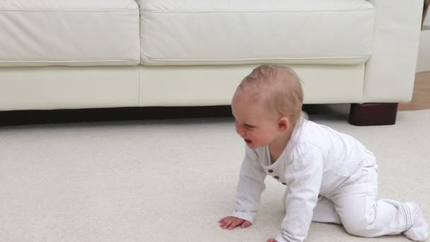 Baby sitzt vor dem Sofa — Stockvideo