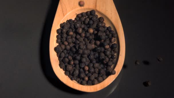 Peppercorns cayendo en cámara súper lenta en una cuchara de madera — Vídeos de Stock