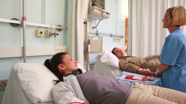 Nurse touching monitor next to transfused patients — Stock Video