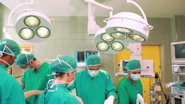 Команда хирургов во время операции — стоковое видео