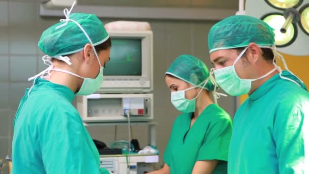 Vista lateral de un equipo quirúrgico operando — Vídeos de Stock
