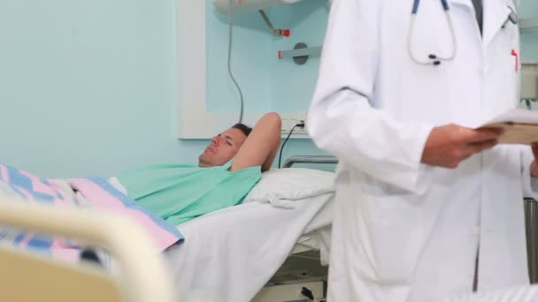 Doctor hablando con un paciente en una sala de cama — Vídeos de Stock