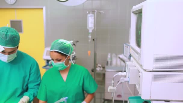 Nurse drying forehead of a concentrated surgeon — Stock Video