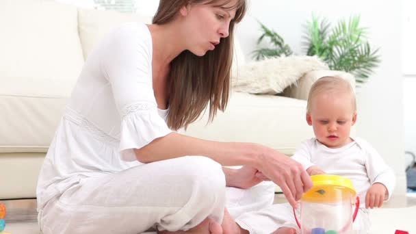 Baby uvedení zelené kostky v kbelíku a žena vítá — Stock video