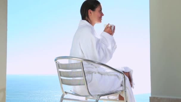 Mujer tomando un café con vista al mar — Vídeo de stock