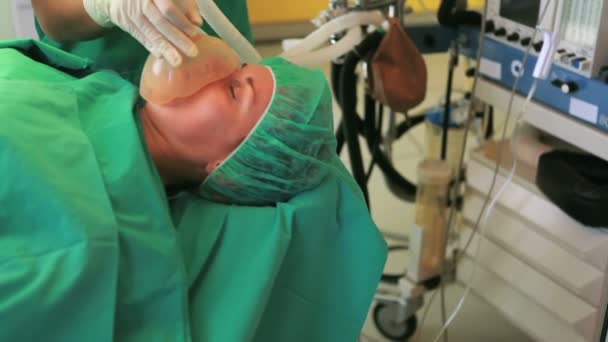 Oxygen mask placed in the face of a patient while a medical team is working — Stock Video