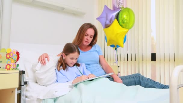 Smiling woman with her girl in a bed — Stock Video