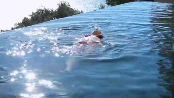 Женщина лежит на спине в бассейне — стоковое видео