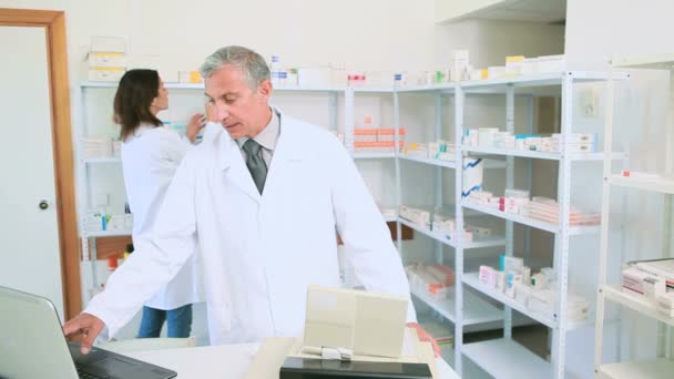 Farmacêutico titular de uma receita médica com um cliente — Vídeo de Stock