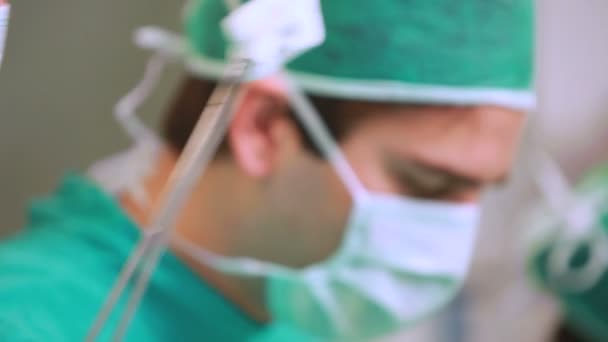 Verpleegkundige dweilen de voorhoofd van een chirurg — Stockvideo