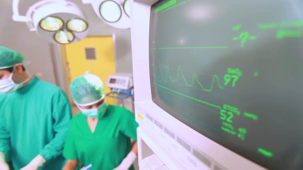 Концентрированный хирург смотрит на монитор — стоковое видео