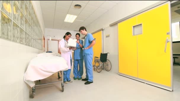 Female doctor talking to male and female nurses in a hallway — Stock Video