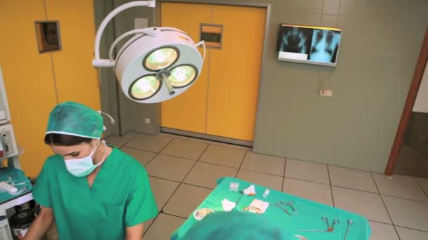 Chirurg und Team operieren einen Patienten, während sie auf einen Monitor schauen — Stockvideo