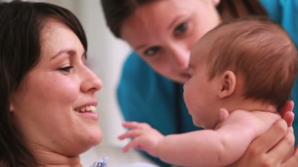 Glad mamma håller en pojke i blöja med en läkare — Stockvideo