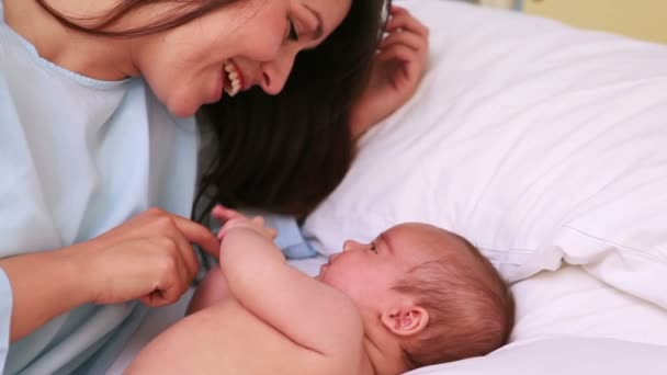Счастливая мать с ребенком в постели — стоковое видео