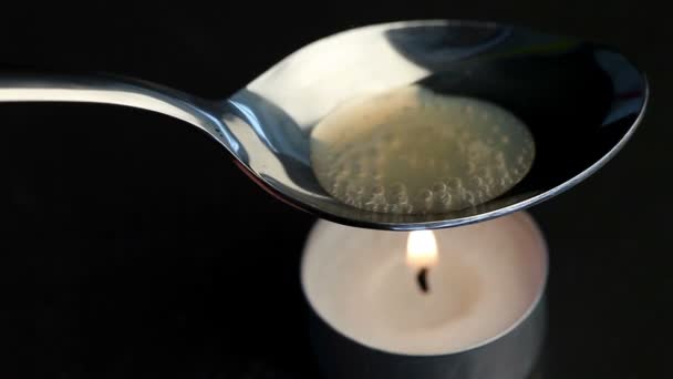Candle heating the spoon — Stock Video