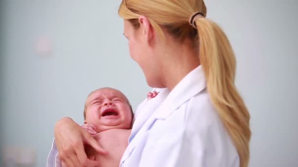 Arzt hält ein Neugeborenes in der Hand — Stockvideo