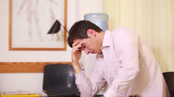 Muž, který držel hlavu, zatímco sedí v čekárně — Stock video