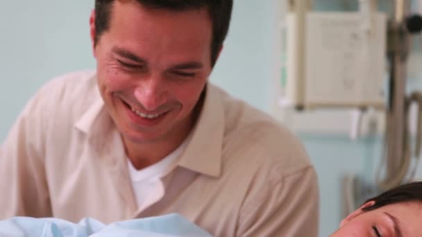 Father looking at his sleeping wife and a newborn baby — Stock Video