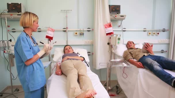 Two transfused patients lying on a medical bed — Stock Video