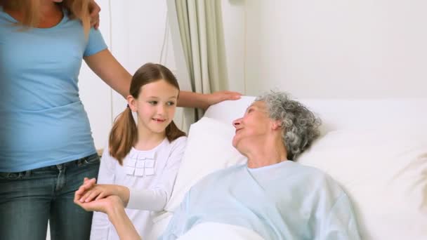 Familia de pie alrededor de una cama de hospital — Vídeo de stock