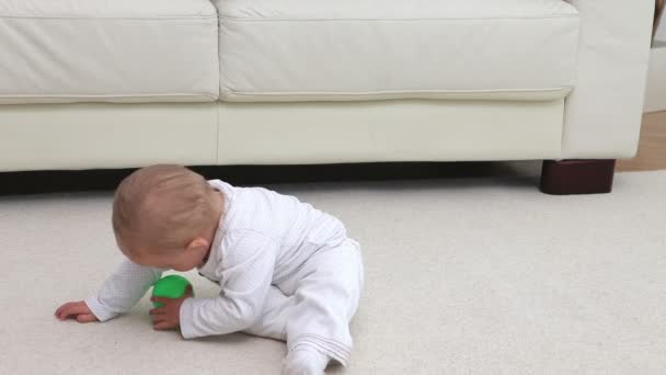 Bebê brincando com uma bola turquesa — Vídeo de Stock