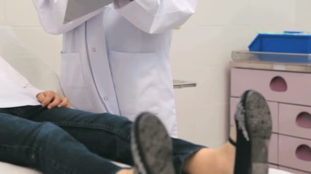 Ärztin im Gespräch mit einer Mutter, während ihre Tochter im Krankenhausbett liegt — Stockvideo