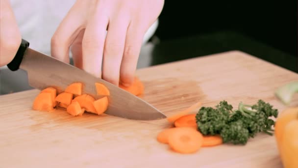 Mujer cortando una zanahoria en cubos en cámara lenta — Vídeos de Stock
