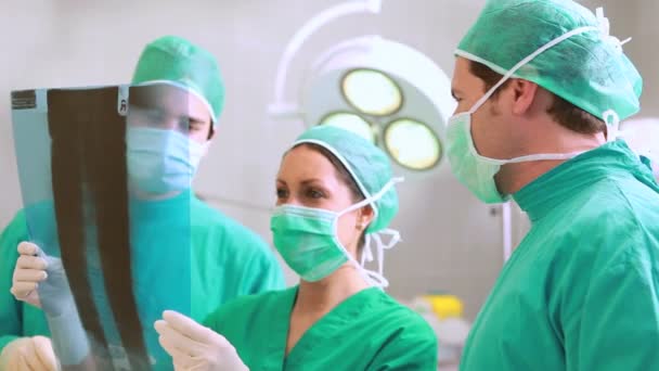 Equipe cirúrgica falando de um raio-X — Vídeo de Stock