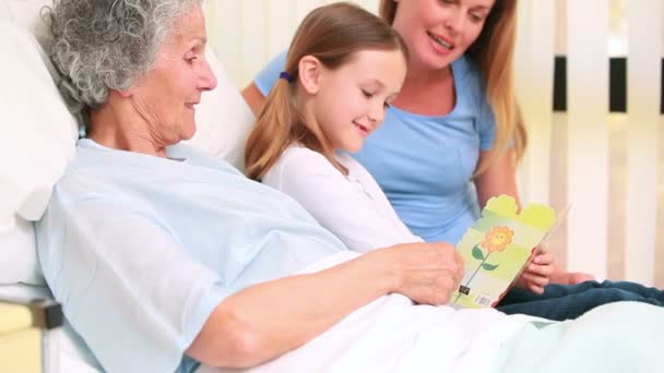 Smiling woman and girl sitting on the bed of a patient — Stock Video