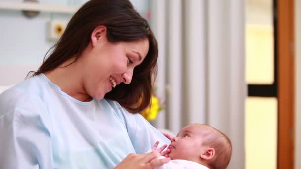 Madre sonriente mirando a un bebé recién nacido — Vídeo de stock