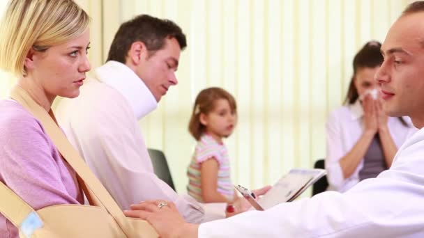 Mujer lesionada hablando con un médico en la sala de espera — Vídeos de Stock