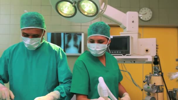 Surgeon placing an oxygen mask on the face of an unconscious patient — Stock Video