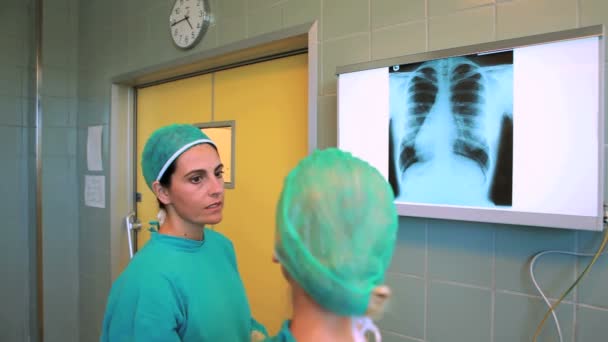 Medizinisches Team schaut sich ein Röntgenbild an — Stockvideo