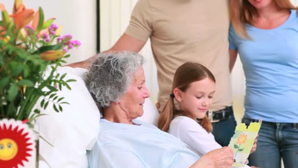 Famiglia sorridente in piedi insieme intorno a un letto d'ospedale — Video Stock