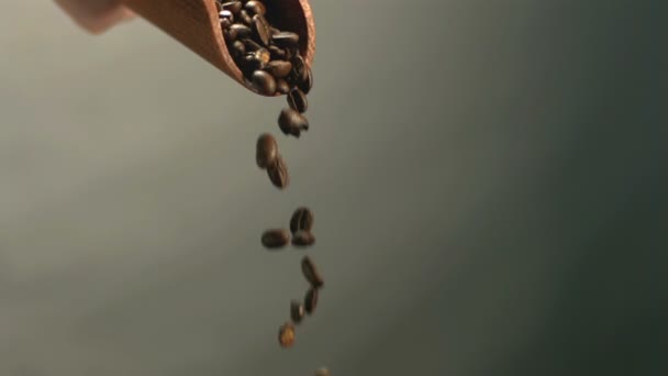 Кофейные зерна, выливающиеся из деревянного черпака — стоковое видео