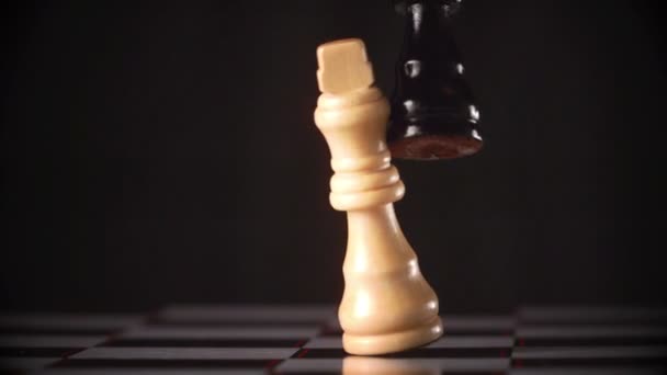 Black king knocking over white king — Stock Video