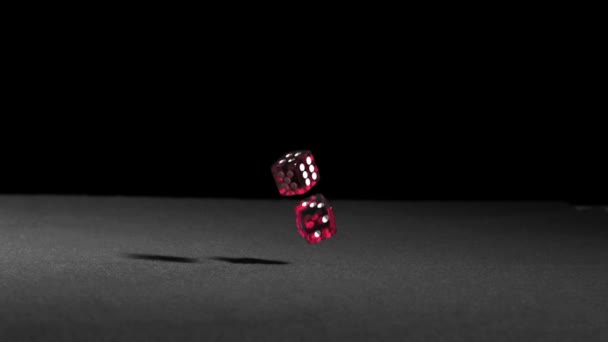 Pink dice falling on black table — Stock Video