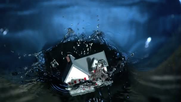 Miniature model house falling into water — Stock Video