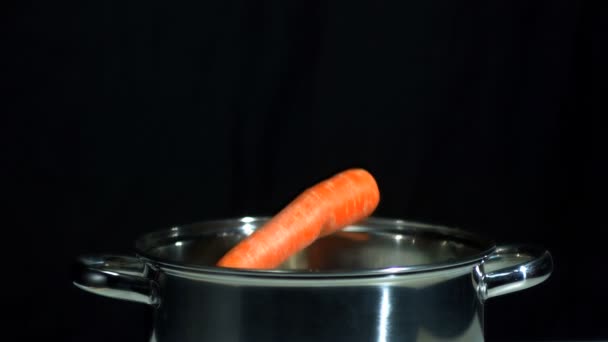 Морковь падает в кастрюлю — стоковое видео