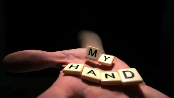 Mano agarrando piezas de letras deletreando mi mano — Vídeo de stock