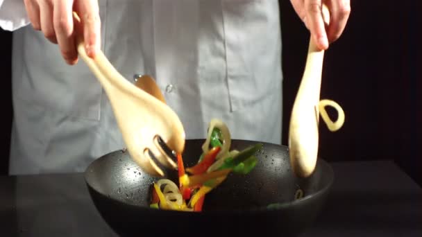 Chef-kok mengen plantaardige roerbak in een wok — Stockvideo